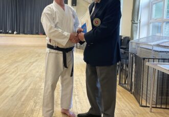 Sam receives his 1st Dan award (for the second time) from Sensei Reg